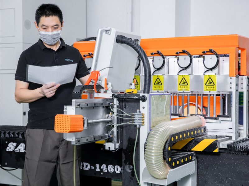 man checking a sheet beside factory equipment